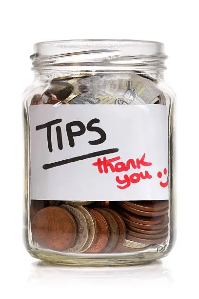 Tip jar with British currency and label saying thank you