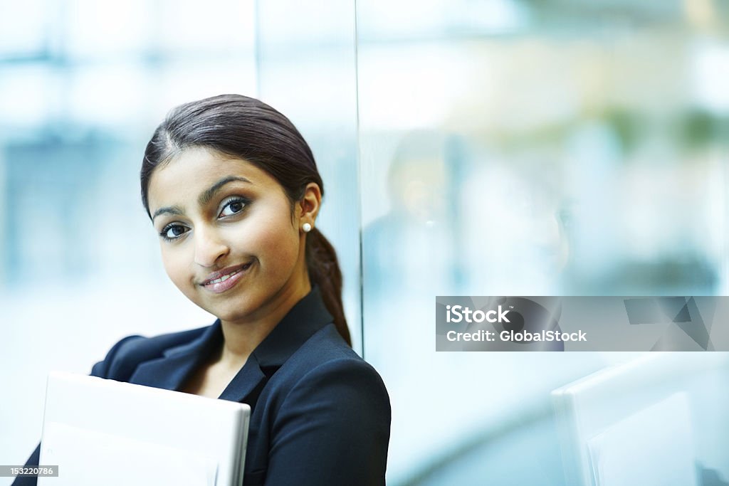 Деловая женщина держит ноутбук и улыбается - Стоковые фото 20-24 года роялти-фри