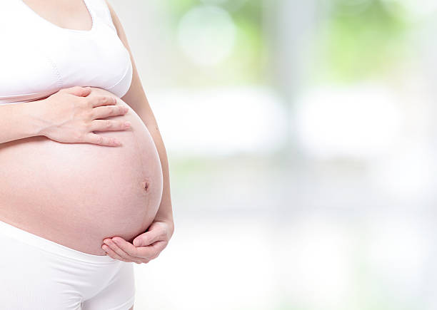 istock expectant mother touching her belly by hands 153221980