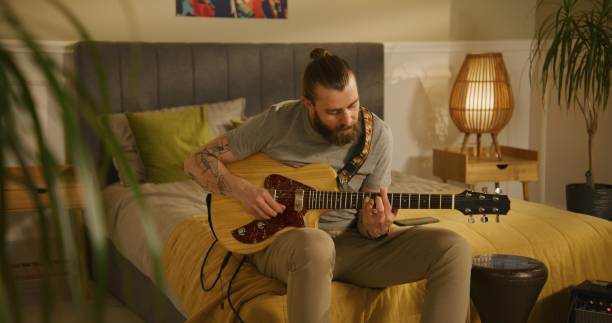istock Man plays guitar in bedroom. 1532231339