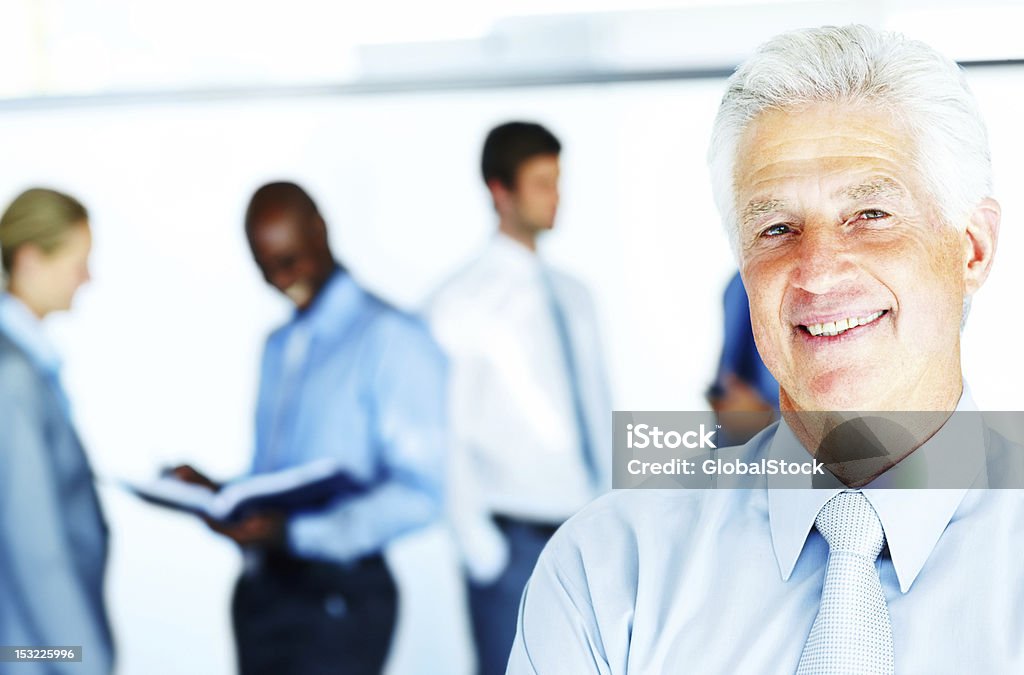 Geschäftsmann Lächeln mit business-Menschen im Hintergrund - Lizenzfrei Aktiver Senior Stock-Foto