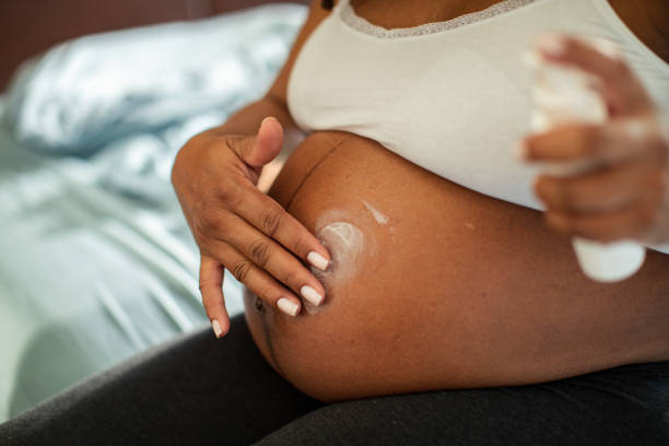 istock Young pregnant Hispanic woman using a spray cream on her belly 1532275158