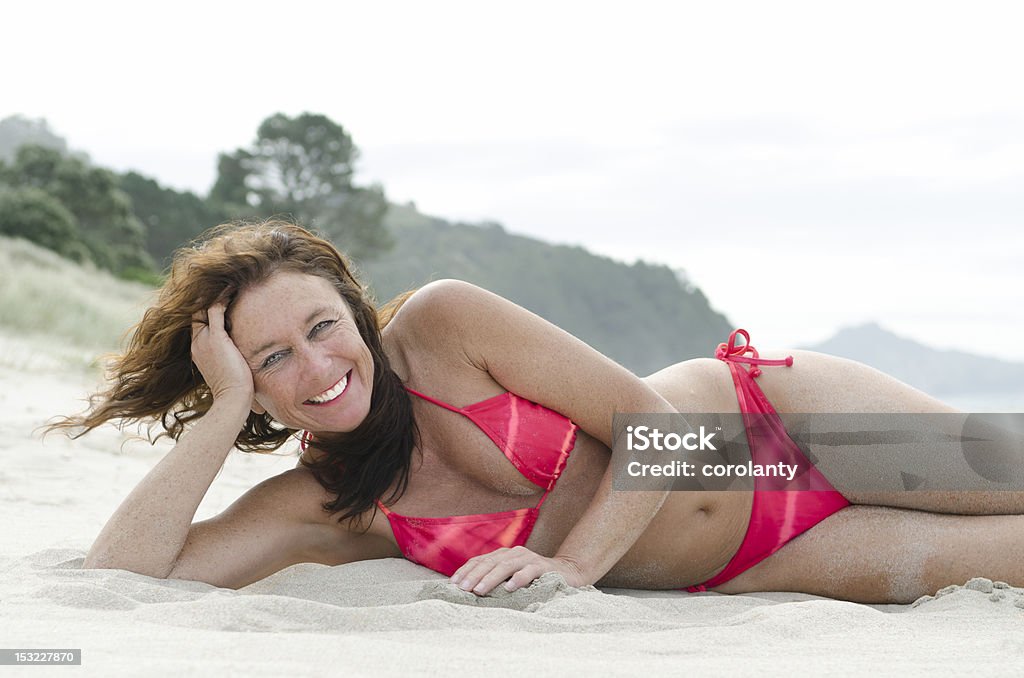 terwijl Kustlijn nauwelijks Happy Mature Woman On Beach Stockfoto en meer beelden van Oudere vrouwen - Oudere  vrouwen, Bikini, Alleen één vrouw - iStock