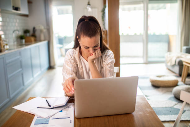 istock Young woman going over her finances at home while using her laptop 1532302228