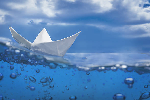 istock paper ship splash bubbles sailing blue water and sky 153233679