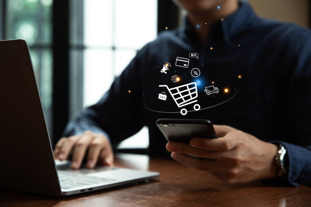 istock Young man using smartphone with shopping cart icon. 1532353454