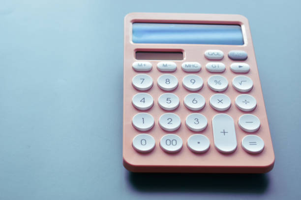 istock close up modern peach colour pastel calculator and white button on blue background, business and finance accounting concept 1532357103