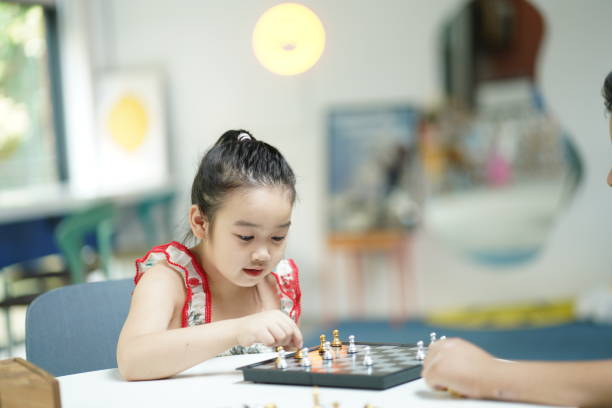 istock Little Asian girl playing chess joyfully 1532378702