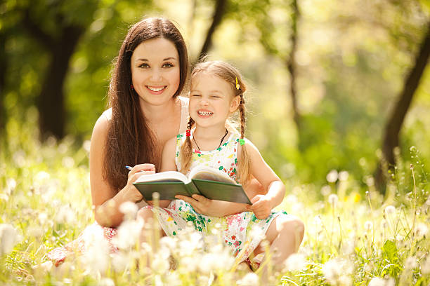 istock Mother and daughter drawing on grass in park 153238079