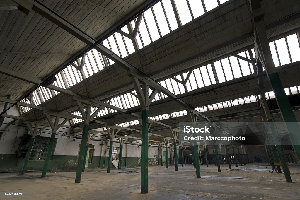 dark, old factory hall with roof windows dark,old,empty factory hall with roof windows. photo is taken with dslr camera and wide angle lens in abandoned factory. Architecture Stock Photo