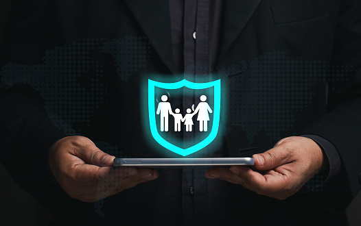 Family security concept. Businessman holding smartphone virtual screen, family icon in security icon. insurance business, life insurance, future planning long term financial investment.
