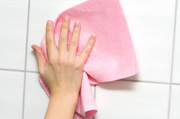 Female hand cleaning wall with rag