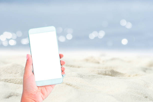 istock hand hold smartphone and beach background 1532449239