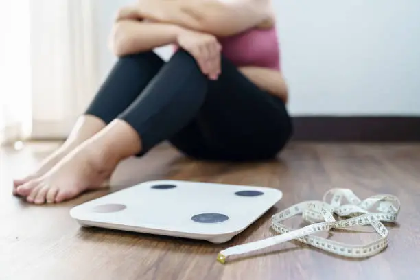 Photo of Obese Woman with fat upset bored of dieting Weight loss failÂ  Fat diet and scale sad asian woman on weight scale at home weight control