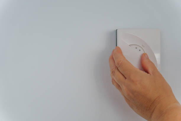 istock woman lowering the thermostat temperature 1532462216