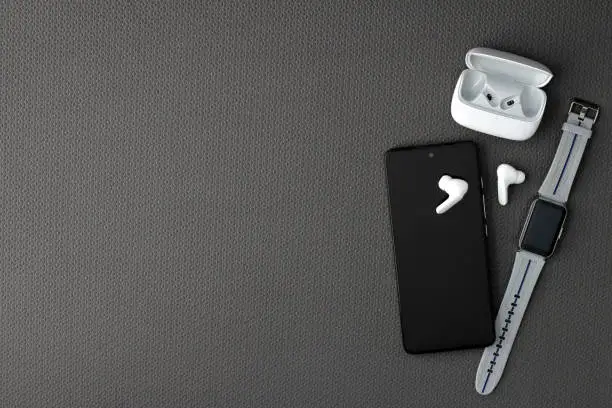 Photo of Objects to exercise on a mat with cell phone, apple, bottle of water, headphones, tennis towel and watch