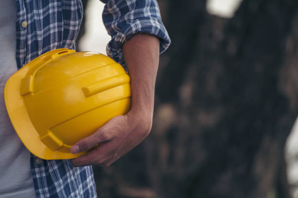 istock Engineer man hands holding hardhat white work helmet hard hat for Civil Construction Engineering. Construction engineer man in safety suit hold white work helmet hard hat on hands at Construction Site 1532512493