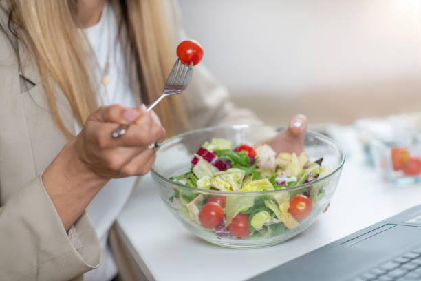 istock Woman Eating Fresh Salad at Workplace 1532529592