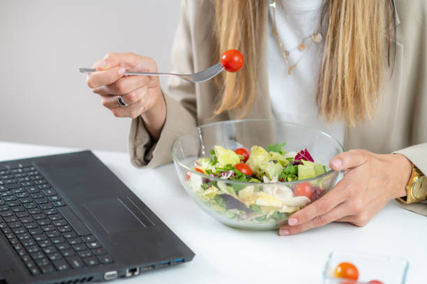 istock Woman Eating Fresh Salad at Workplace 1532531360