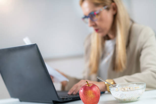 istock Productivity Boost: Woman's Focused Work with Apple and muesli by Her Side 1532532934