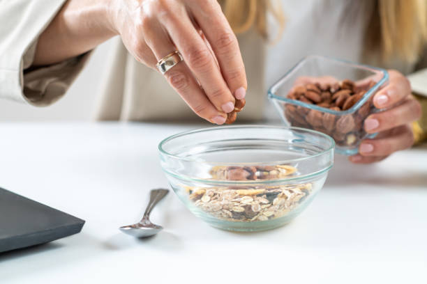 istock Woman Prepares Nutritious Muesli with Almonds and Hazelnuts at Work 1532535981