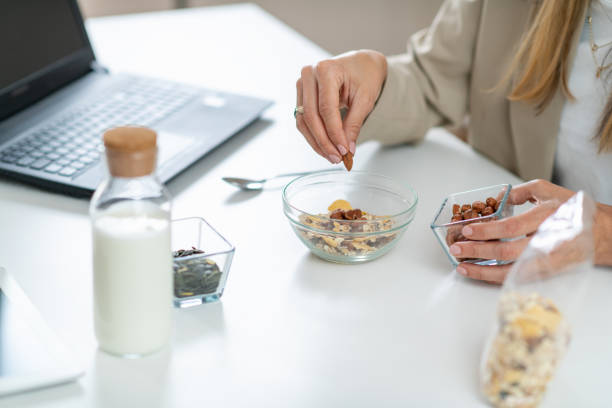 istock Woman Crafts Nutritious Muesli Bowl with Yogurt, Almonds, and Hazelnuts 1532537544