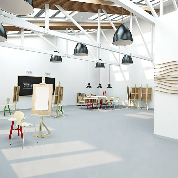 Empty art workroom with easels, stools, and a table in back stock photo