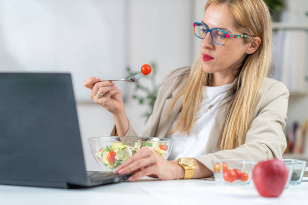 istock Woman Eating Fresh Salad at Workplace 1532543718