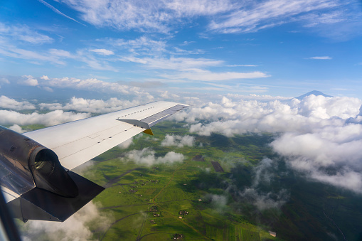 Flying above the earth and above the clouds in the territory of Tanzania, East Africa. Airplane window view. The plane flies in the sky above the earth.