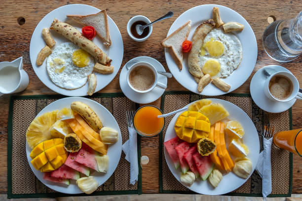 istock Tropical breakfast of fruit, coffee and scrambled eggs and banana pancake for two on the beach near sea 1532575238