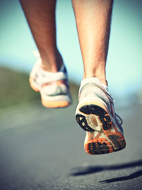 Runnning shoes on runner Running shoes on runner - closeup of sport shoes outdoors on man runner during run.Running sport. Click for more: off track running stock pictures, royalty-free photos & images