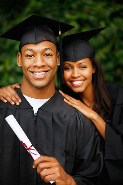 istock Two students in graduation gown holding certificate 153261110