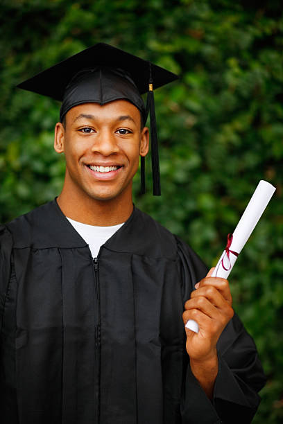 istock Male student in graduation gown holding certificate 153261113