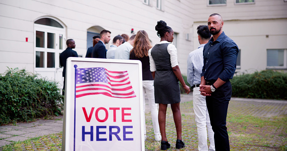 Diverse People At Voting Booth. Vote Here Elections Sign