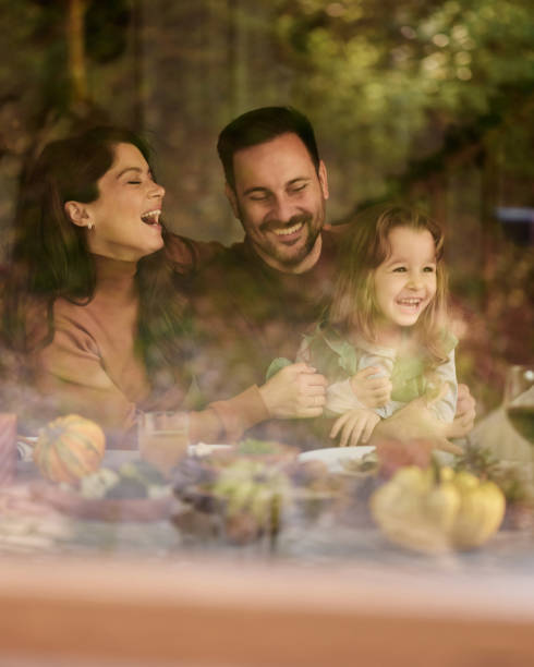istock Cheerful parents having fun with their daughter at dining table. 1532631241