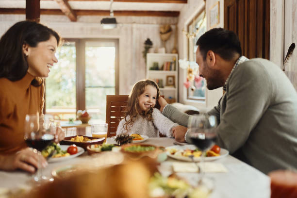 istock Happy girl enjoying with her parents at dining table. 1532636666