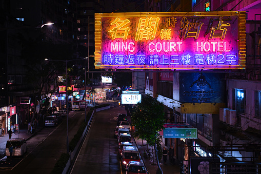 Hong Kong, China - April 28 2023: Colorful Neon light Sign of a hotel and red taxi line at night on Lockhart Road