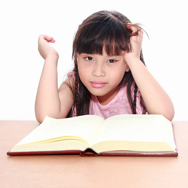 istock serious little girl  reading a book 153266908