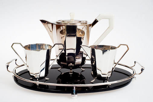 an antique tea set in silver plate on a white background on a black plate