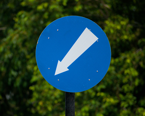 Traffic diversion road sign blue round with white arrow