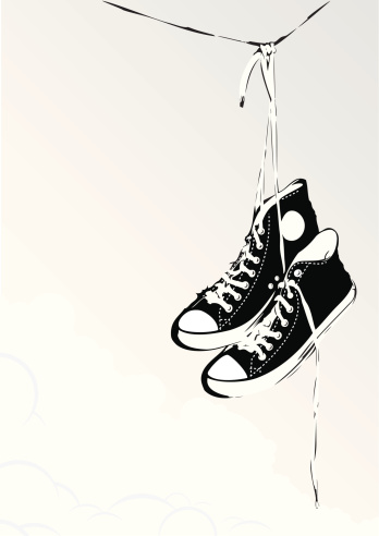 A pair of sport shoes hanging from a line.