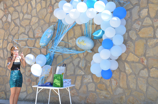 teenager with white and blue balloons