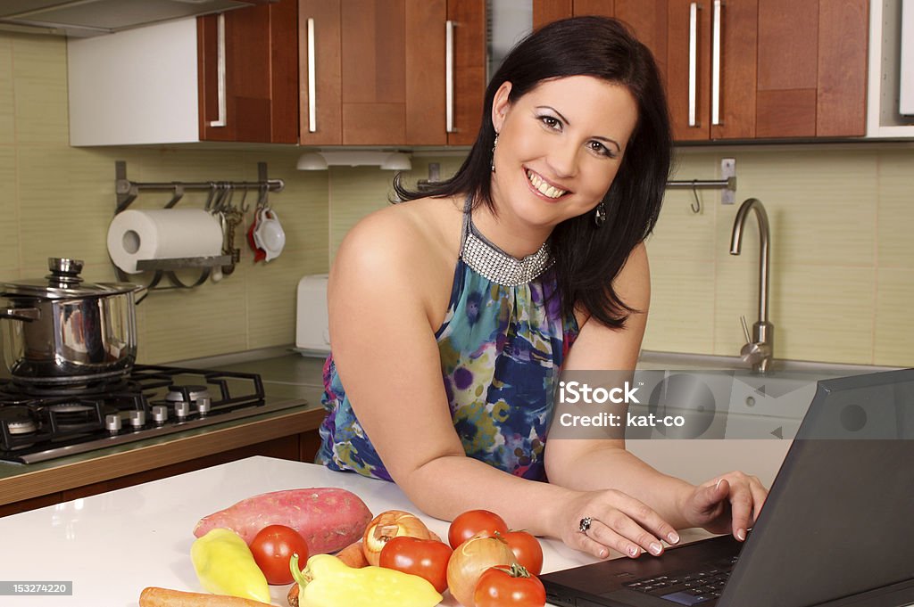 Kobieta w kuchni szuka Recepta - Zbiór zdjęć royalty-free (30-34 lata)