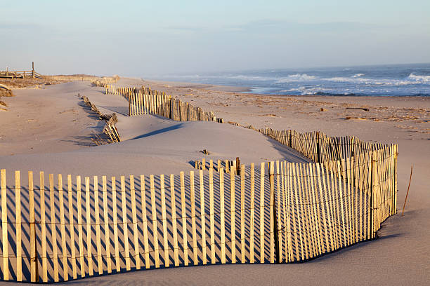 Beach fence, sand and the ocean. The fence holds the sands from eroding into the ocean. Cupsoque beach, Westhampton, Long Island, New York.