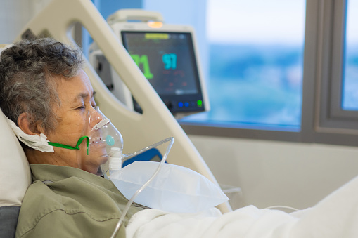 Close-up of a senior woman patient with lung disease, getting oxygen for treatment in the room at the hospital.