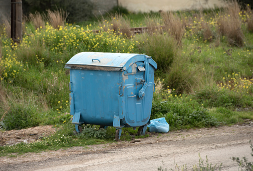 Blue garbage bin and uncollected Waste