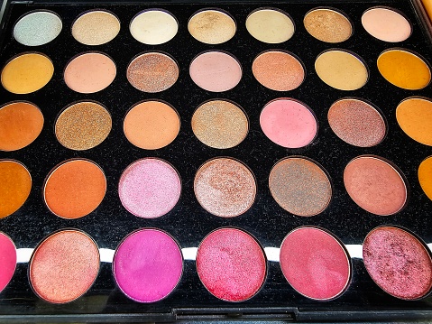 Different colors of eyeshadow in a palette in the cosmetics store.