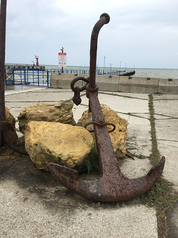 Anapa, Russia - June 16, 2023: Old rusty two-legged anchor in the seaport Anapa.