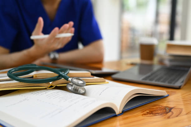 istock Medical student man wearing blue scrubs using digital tablet, preparing for university exams. Medical internship concept. 1532924456