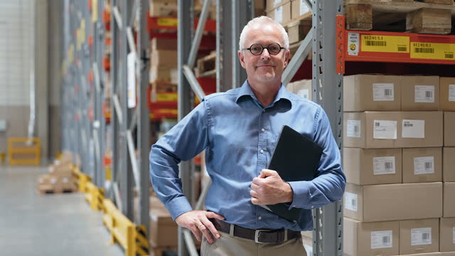 Portrait of mature man leaning to the warehouse storage rack